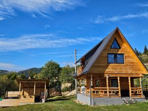 a log cabin with a gambrel roof at Cabana MIYA in Mătişeşti