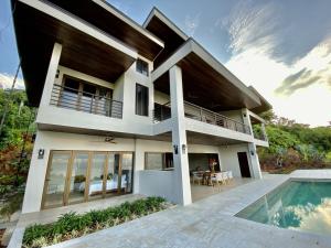 a villa with a swimming pool and a house at RESOL Secluded Ocean-view luxury in the Jungle in Uvita
