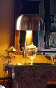 un tavolo con una lampada e una ciotola di vetro sopra di Le Chai de Serres a Artassenx