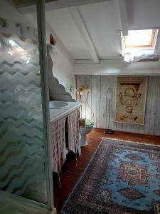 bagno con lavandino, servizi igienici e tappeto di Le Chai de Serres a Artassenx
