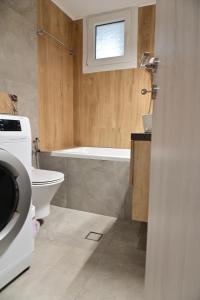 a bathroom with a toilet and a tub and a sink at Adel's Elegance Stays in Alexandroupoli +45 photos