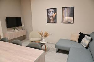 a living room with a couch and a tv at Adel's Elegance Stays in Alexandroupoli