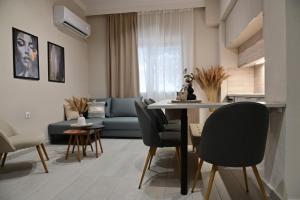 a living room with a couch and a table and chairs at Adel's Elegance Stays in Alexandroupoli