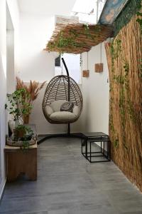 a room with a rattan chair and a table at Adel's Elegance Stays in Alexandroupoli