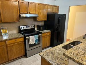 a kitchen with wooden cabinets and a stove and refrigerator at Atlanta Cozy Private Room 4 in Atlanta +8 photos