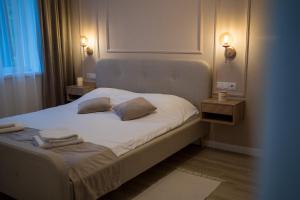 a bedroom with a bed with two pillows on it at Zena Apartment in Ocna-Mureşului