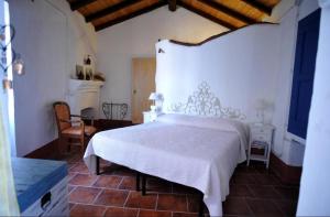 a bedroom with a large white bed in a room at B&B Corte San Lussorio in Oliena