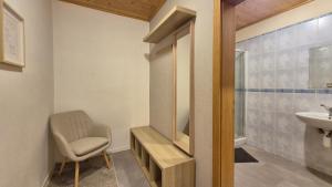a bathroom with a chair and a sink at Apartmán Kragujevská in Žilina