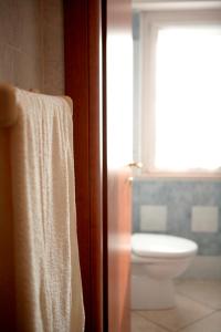 ヴェローナにあるMansarda Carolinaのバスルーム(トイレ付)、ドアにタオルを用意しています。
