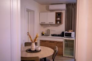 a small kitchen with a table and a table and chairs at Zena Apartment in Ocna-Mureşului