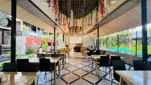 a restaurant with tables and chairs and a clock at Coastal Bay Inn Resort in Alibaug