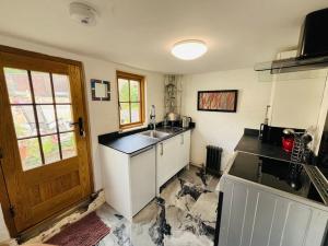 a kitchen with a sink and a counter top at Beautifully Quaint Cottage in Yelling