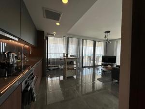 a kitchen and living room with a couch and a table at Grand Sapphire Luxury Corner Apartment with Spectacular Views and Two Bedrooms by MyGuest Cyprus in Iskele +40 photos
