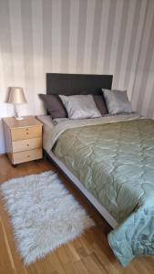 a bedroom with a large bed with a nightstand and a white rug at Kodikas koti in Lapua