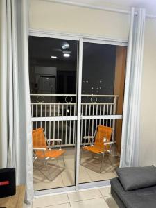 a room with a balcony with two chairs and a couch at Apartamento Smart in São Carlos