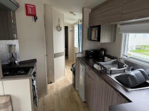 a kitchen with a sink and a counter top at Millie’s caravan in Abergele