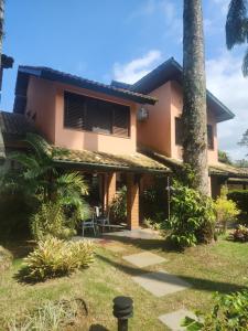 a house with a palm tree in front of it at Casa em Villagio na Riviera in Riviera de São Lourenço