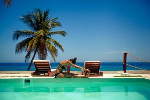 a woman in a bikini next to a swimming pool at Casa del Mar Lodge Barahona in Santa Cruz de Barahona