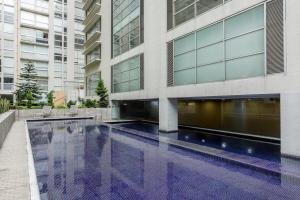 a building with a swimming pool in front of it at Condominio Premium al Lado de la Plaza Antara Polanco Carso in Mexico City