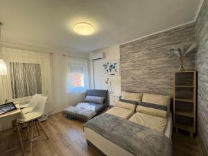 a living room with a bed and a desk and a desk at Szeged Sunshine Apartman in Szeged
