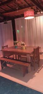 a wooden table with two chairs and a bench at LE BOUTIQUE SUÍTES - PRAIA de MARESIAS in Maresias