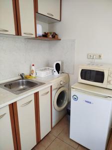 a kitchen with a sink and a microwave and a dishwasher at Aria private apartments in Fort Noks Grand Resort - Saint Vlas in Elenite