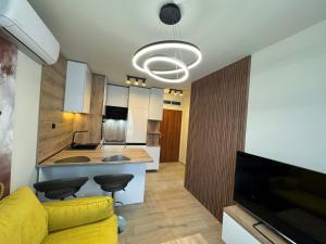 a living room with a yellow couch and a kitchen at Luxury flat in Pleven in Pleven