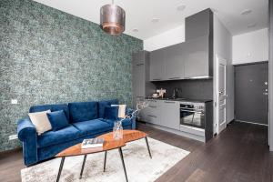a living room with a blue couch and a table at Vilnius Old-Town Renaissance Studios in Vilnius
