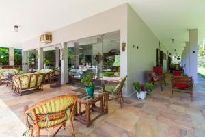 un patio avec des chaises et une table ainsi qu'un restaurant dans l'établissement Suites Prime Itamambuca, à Ubatuba
