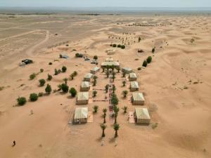 an aerial view of a desert with a group of tents at Anir Luxury Camp - Gites et Tentes de Luxe in Merzouga