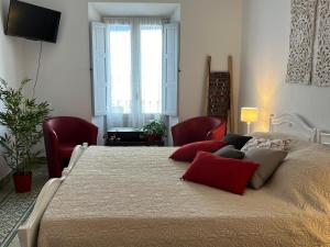 a bedroom with a large bed with red pillows at Bed&Breakfast Al Campanario in Cómpeta
