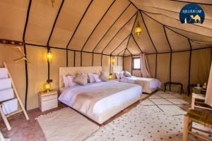 a bedroom with two beds in a tent at Anir Luxury Camp - Gites et Tentes de Luxe in Merzouga