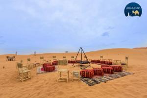 a desert with a table and chairs in the sand at Anir Luxury Camp - Gites et Tentes de Luxe in Merzouga