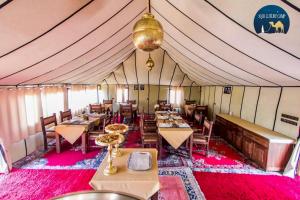 a dining room with tables and chairs in a tent at Anir Luxury Camp - Gites et Tentes de Luxe in Merzouga +37 photos