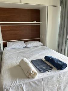 een bed met twee handdoeken en een badjas erop bij Espaço aconchegante in Salvador