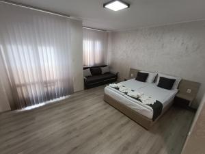 a bedroom with a bed and a couch in it at Комплекс Кантона in Razhishte