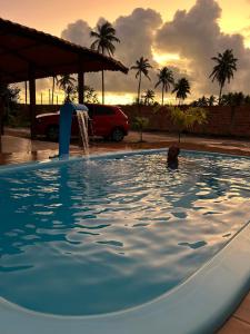 eine Person in einem Pool mit einem Springbrunnen in der Unterkunft Recanto do jao in Maragogi