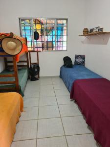 a room with two beds and a window at Quarto para mulheres in Ubatuba