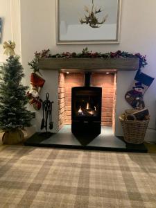 a living room with a fireplace and a christmas tree at Woodland Cottage - private courtyard - Pet Friendly Retreat in the heart of Windermere in Windermere
