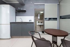 a kitchen with a table and chairs and a sink at Simple Studio in Sea Point in Cape Town
