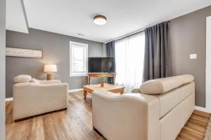 a living room with white furniture and a flat screen tv at Cozy 4 Bedroom Home in Cornwall in Cornwall