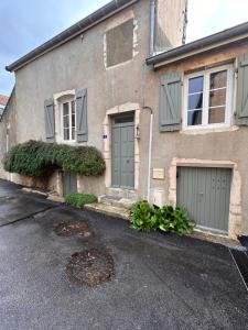 a house with green doors and a manhole at Le Petit Clos au coeur de Puligny-Montrachet in Puligny-Montrachet