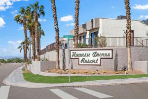 Un cartel delante de un edificio con palmeras. en WorldMark Havasu Dunes, en Lake Havasu City