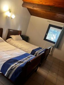 two beds in a room with a window at restaurant japonais Tokogine chambre d hote in Listrac-Médoc