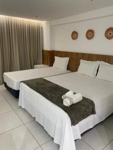 due letti in una stanza d'albergo con asciugamani sopra di Inova Flat no centro a Palmas Altre 9 foto