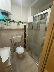 a bathroom with a toilet and a glass shower at House Lurokè in Catania +33 photos