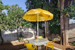 einen Tisch mit gelbem Regenschirm und Stühlen in der Unterkunft House Marko in Orebić + 11 Fotos