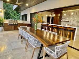 a kitchen with a wooden table and chairs at RESOL Secluded Ocean-view luxury in the Jungle in Uvita