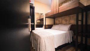 a bedroom with a large bed with white sheets at Uny Hotéis Brás in São Paulo