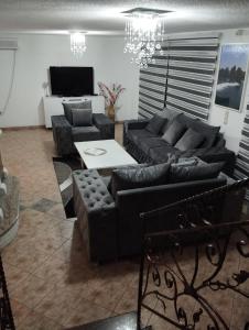 un soggiorno con divani neri e tavolo di City villa Bihac a Bihać